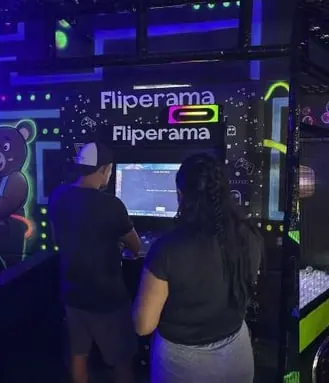 Convidados jogando no fliperama durante a festa